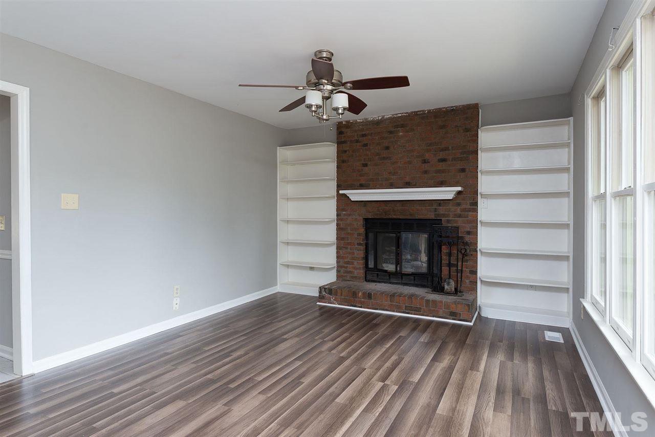 4216 Labrador Drive Raleigh, NC 27616 - Photo 3 of 20 a view of an empty room with wooden floor fireplace and a window