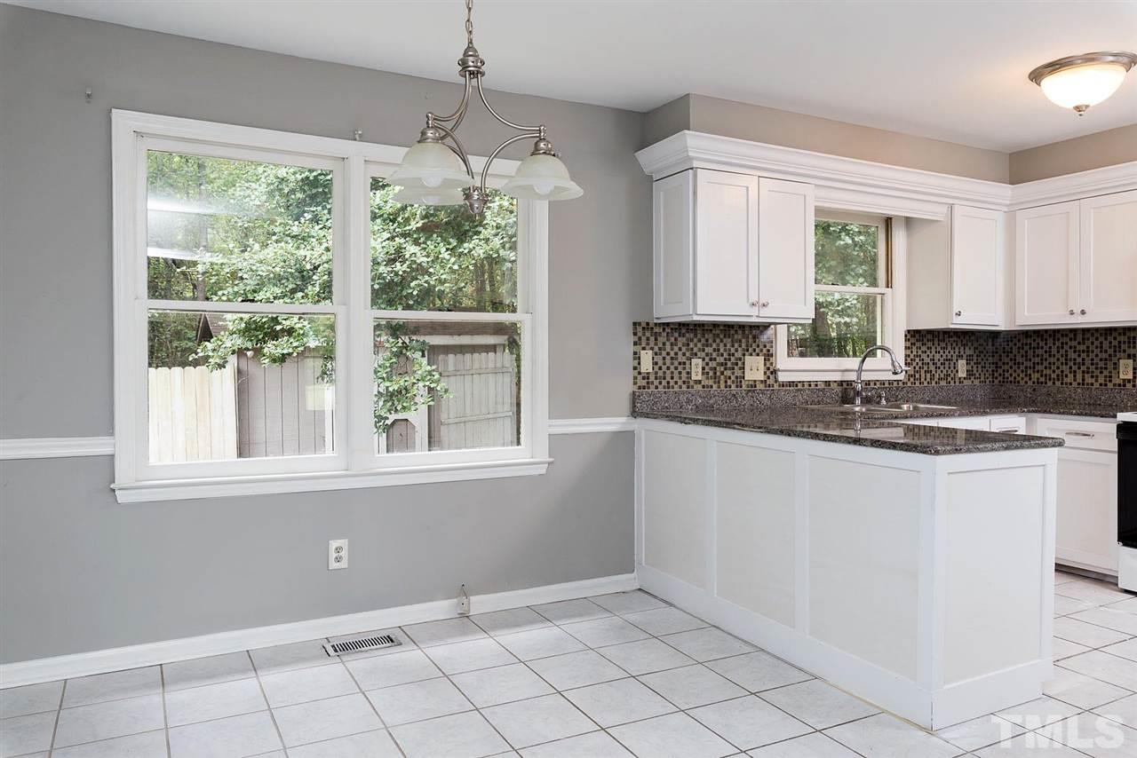 4216 Labrador Drive Raleigh, NC 27616 - Photo 6 of 20 a kitchen with granite countertop white cabinets and window