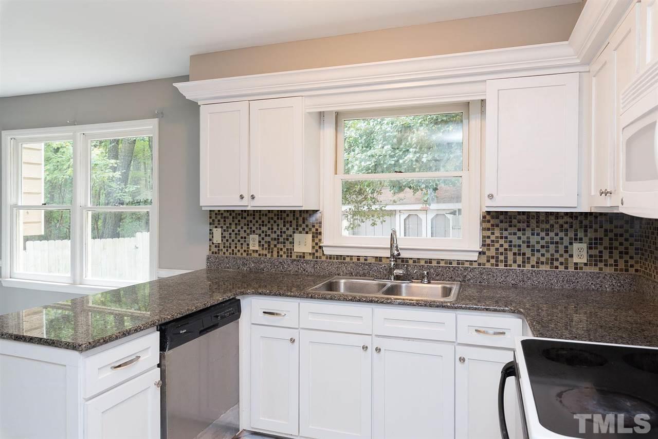 4216 Labrador Drive Raleigh, NC 27616 - Photo 8 of 20 a kitchen with granite countertop a sink window and cabinets