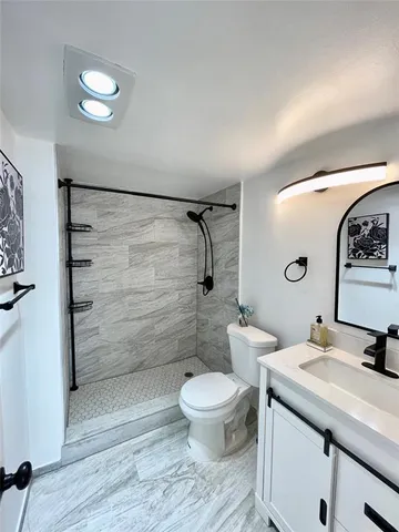 a bathroom with a sink a toilet and shower