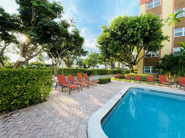 a view of a swimming pool with a lounge chair and a fire pit