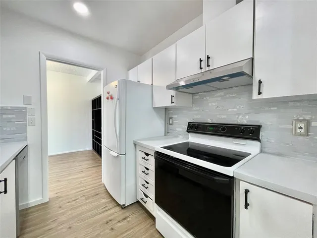 a kitchen with a refrigerator stove and cabinets