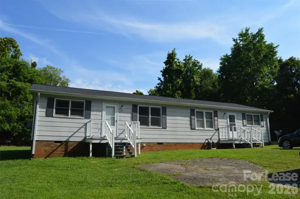 a view of a house with a yard and sitting area