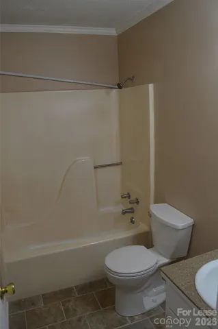 a white toilet sitting next to a bath tub and a shower