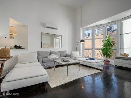 a living room with furniture wooden floor and a large window