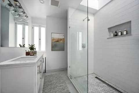 a bathroom with a sink a mirror and shower