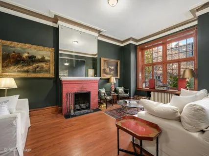 a living room with furniture a fireplace and a large window