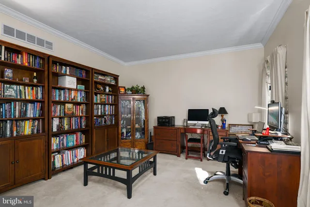 a view of a workspace with furniture and book shelf