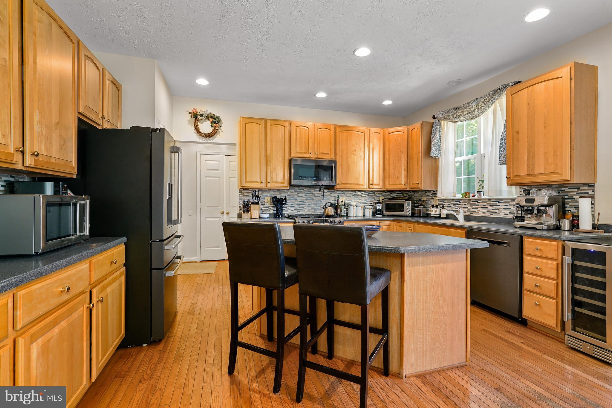 41 Austins Way Elkton, MD 21921 - Photo 16 of 47 a kitchen with stainless steel appliances granite countertop wooden cabinets a refrigerator a stove a sink and a island with wooden floor