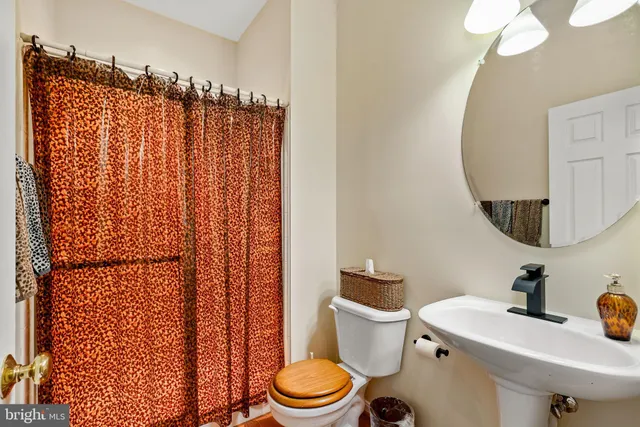 a bathroom with a sink a toilet and shower curtain
