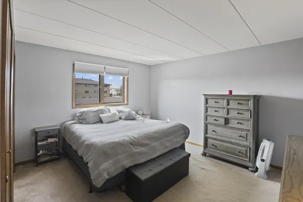 a bedroom with a bed a dresser and book shelf