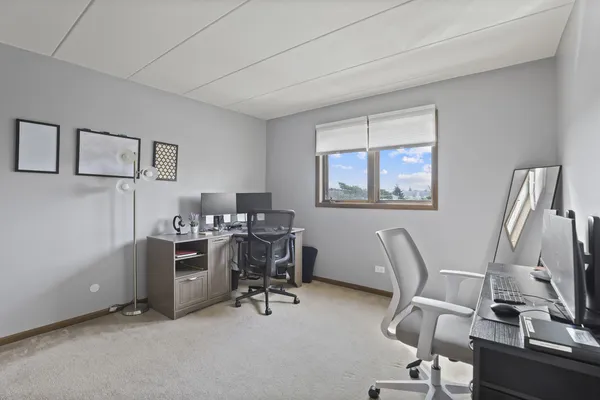 a view of a workspace with furniture and a window