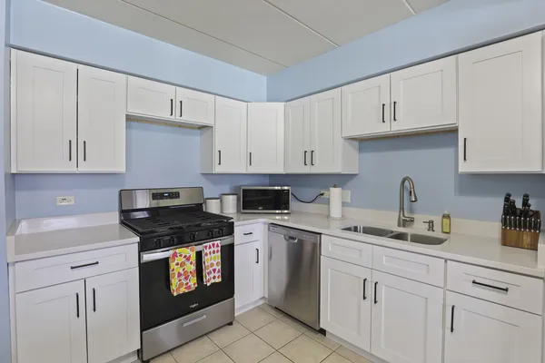 a kitchen with white cabinets and white appliances