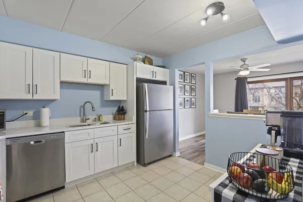 a kitchen with a refrigerator and white cabinets