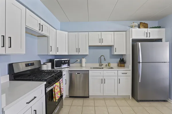 a kitchen with cabinets appliances a sink and a counter top