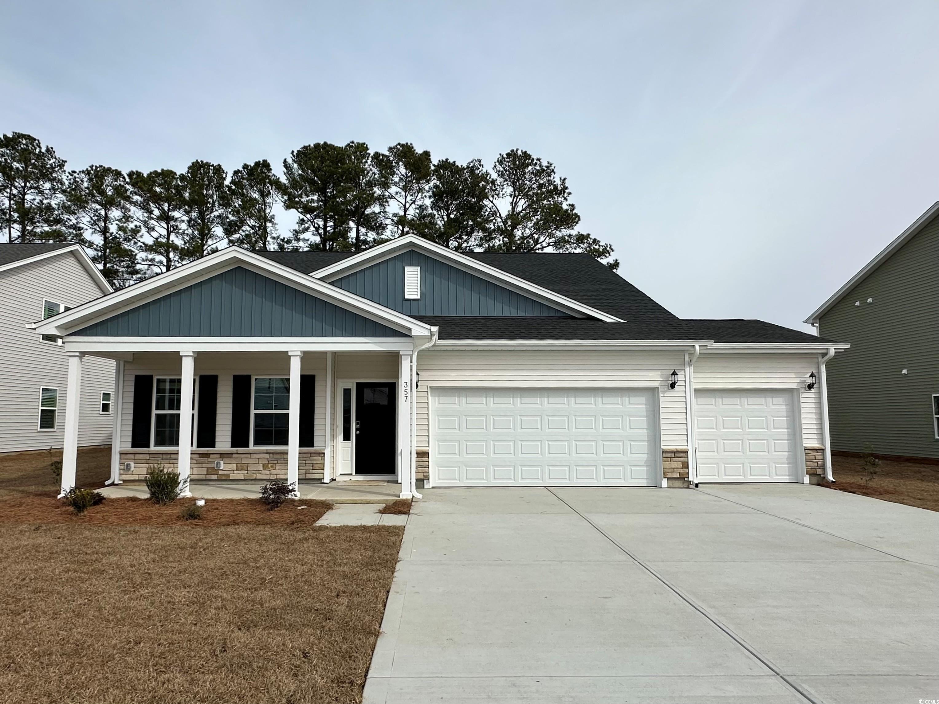View of front of home featuring stone siding, covered porch, driveway, an attached garage, and a shingled roof