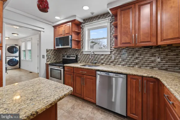 a kitchen with stainless steel appliances granite countertop a sink stove and cabinets