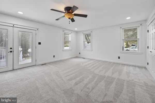 a view of a big room with chandelier fan and windows