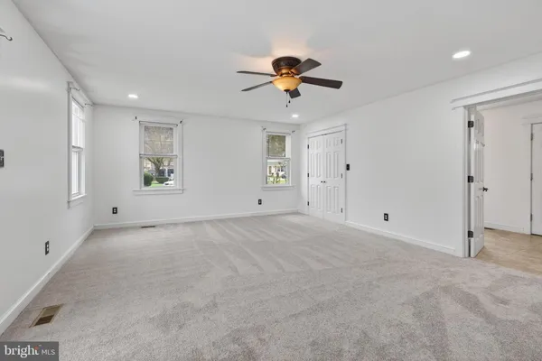 a bedroom with a large bed and a chandelier fan