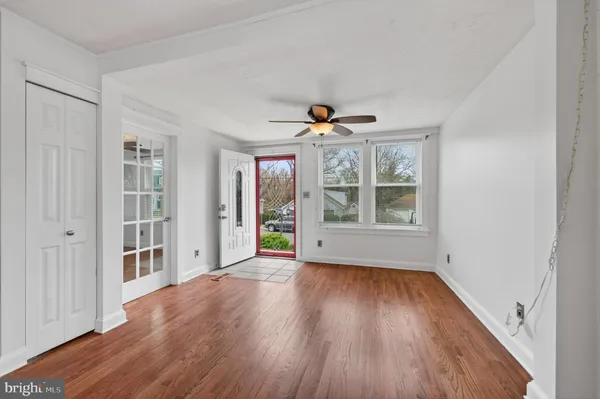 a view of an empty room with a window and wooden floor