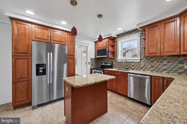 a kitchen with stainless steel appliances granite countertop a refrigerator and a sink