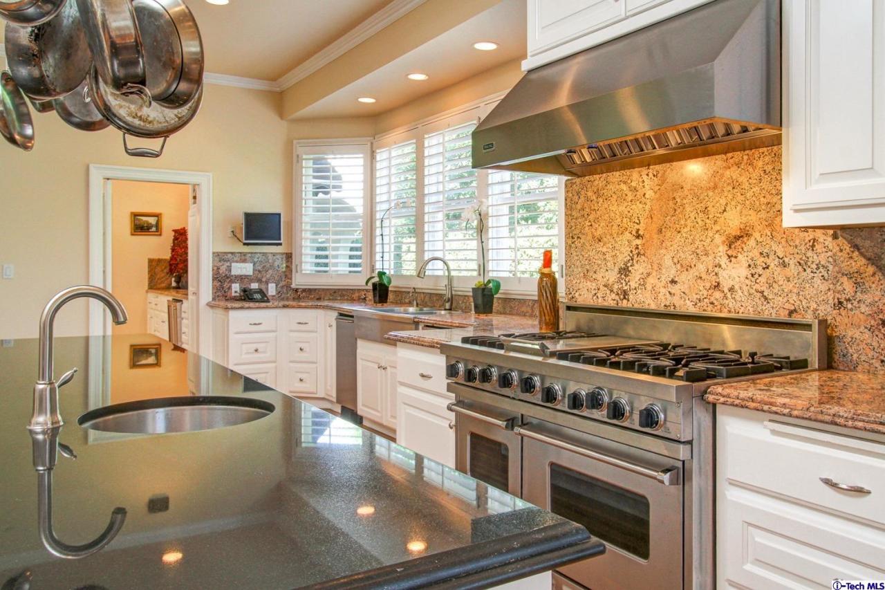 1680 Lombardy Road Pasadena, CA 91106 - Photo 21 of 71 a kitchen with stainless steel appliances granite countertop a stove a sink and a microwave