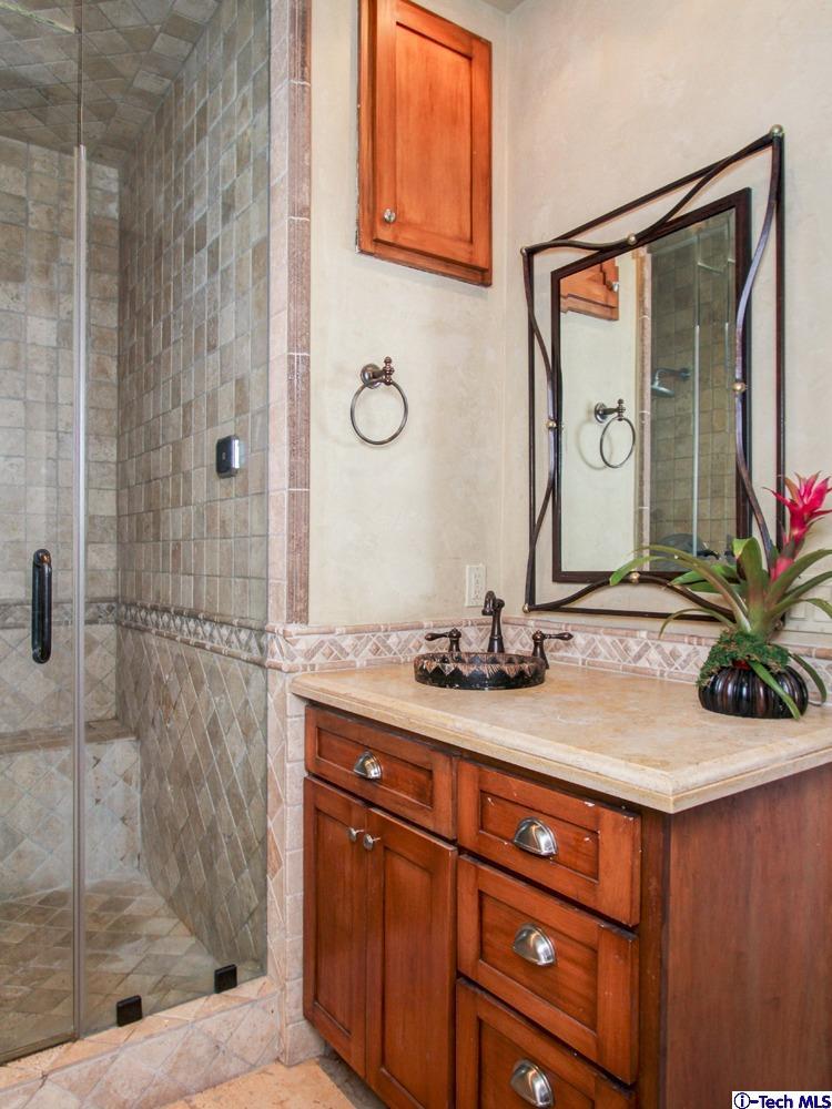 1680 Lombardy Road Pasadena, CA 91106 - Photo 56 of 71 a bathroom with a granite countertop sink a mirror and shower