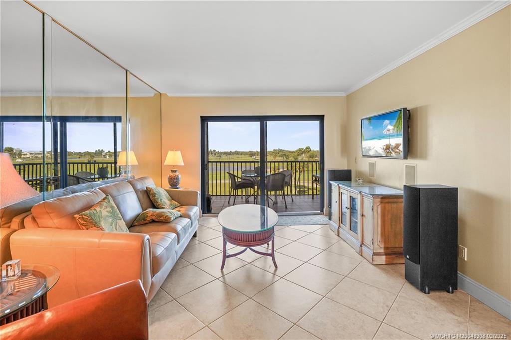 40 Northeast Plantation Road, Unit 415 Stuart, FL 34996 - Photo 12 of 32 a living room with furniture and a floor to ceiling window