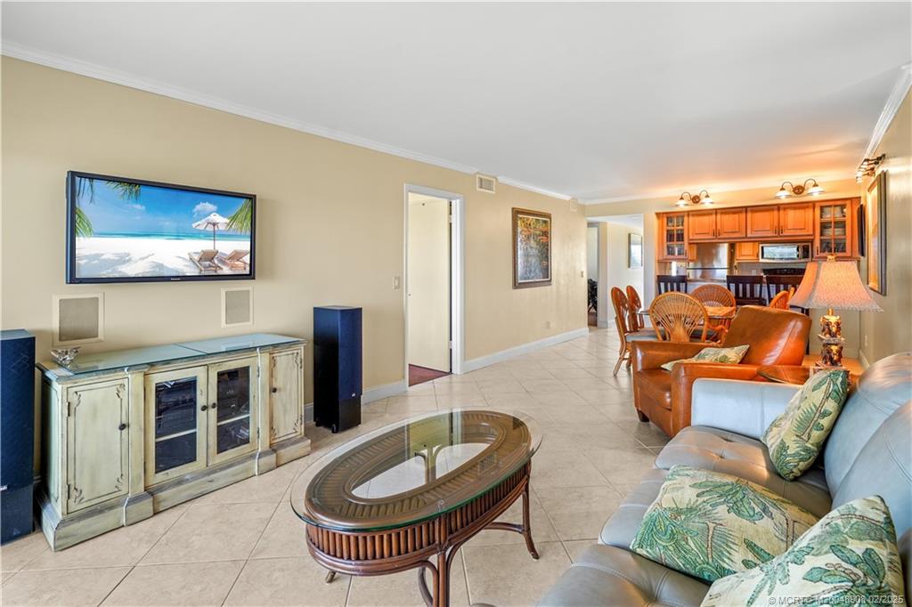 40 Northeast Plantation Road, Unit 415 Stuart, FL 34996 - Photo 14 of 32 a living room with furniture a flat screen tv and kitchen view