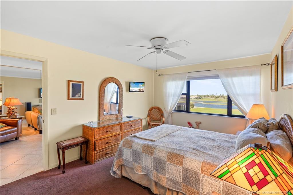 40 Northeast Plantation Road, Unit 415 Stuart, FL 34996 - Photo 15 of 32 a bedroom with a bed and dresser with mirror