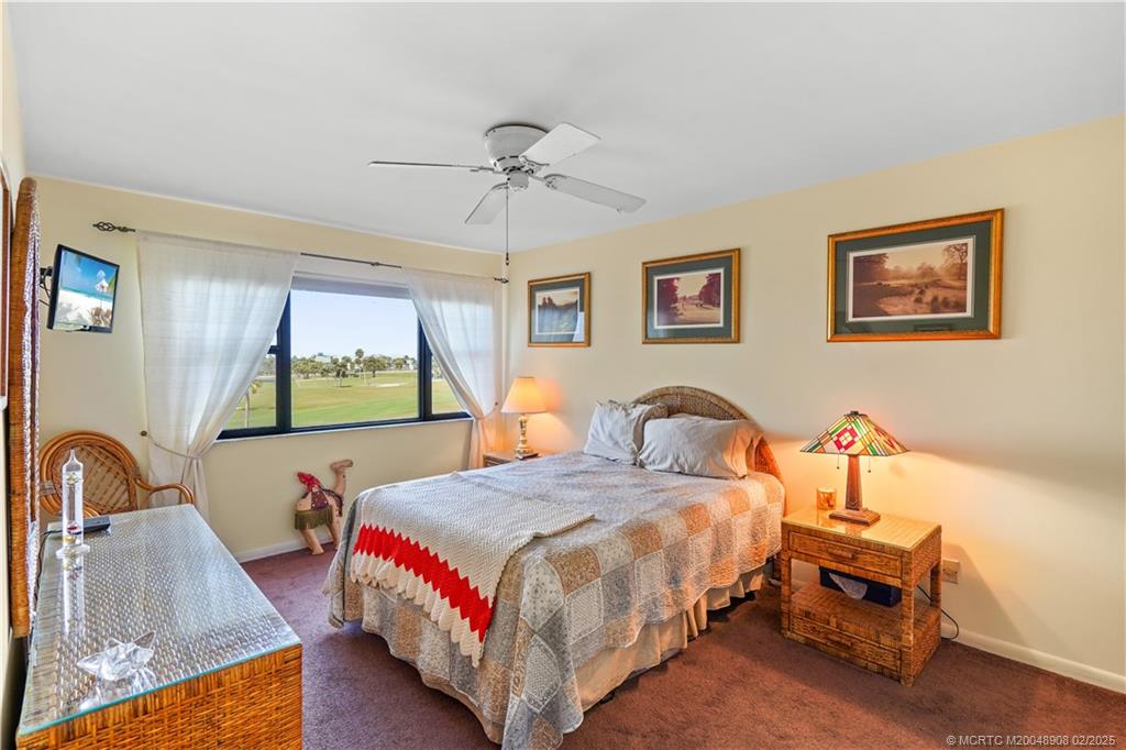 40 Northeast Plantation Road, Unit 415 Stuart, FL 34996 - Photo 16 of 32 a bedroom with a bed a couch and dresser