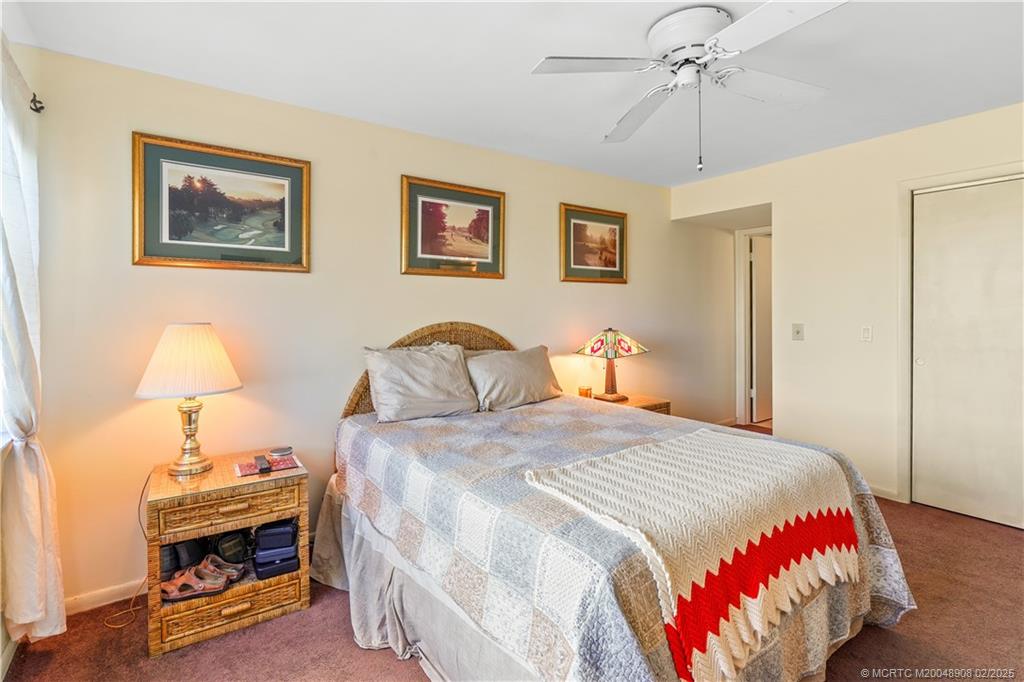 40 Northeast Plantation Road, Unit 415 Stuart, FL 34996 - Photo 17 of 32 a bedroom with a bed and a lamp on table