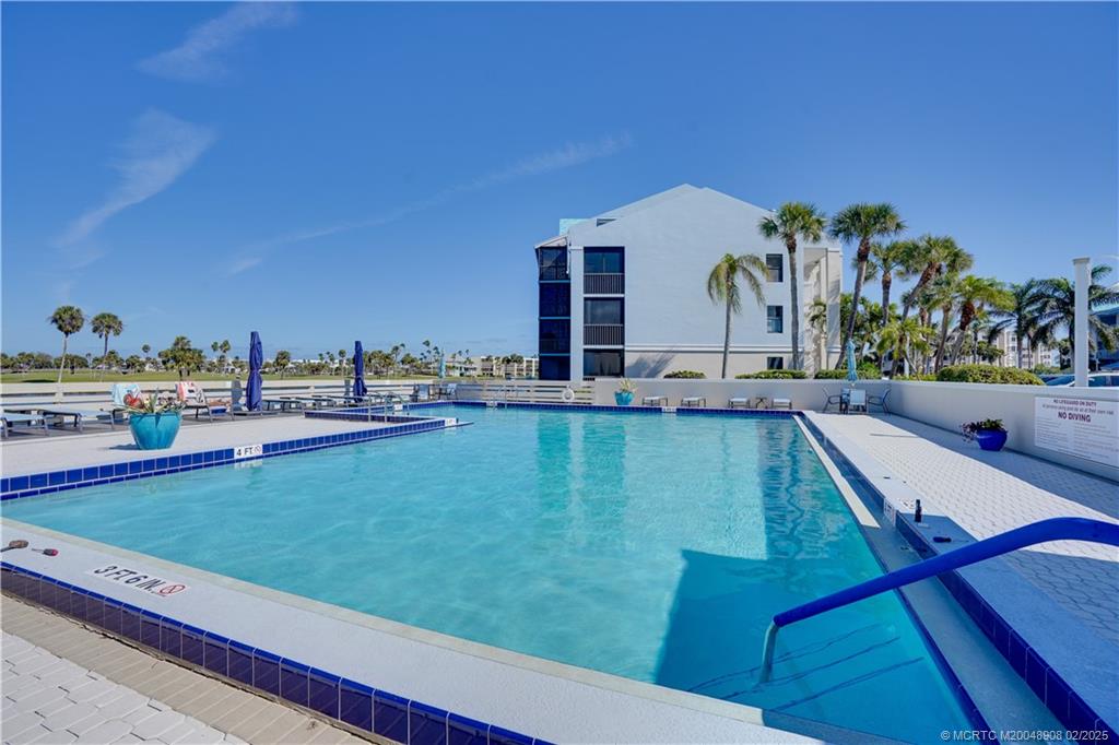 40 Northeast Plantation Road, Unit 415 Stuart, FL 34996 - Photo 24 of 32 a view of a swimming pool with lawn chairs