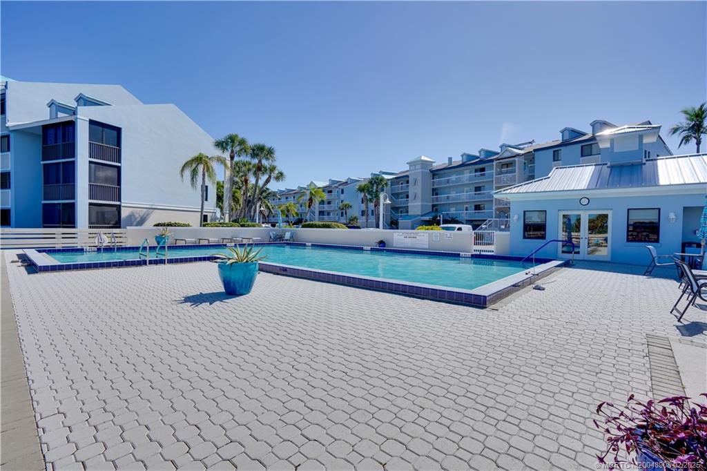 40 Northeast Plantation Road, Unit 415 Stuart, FL 34996 - Photo 25 of 32 a swimming pool with buildings in the background