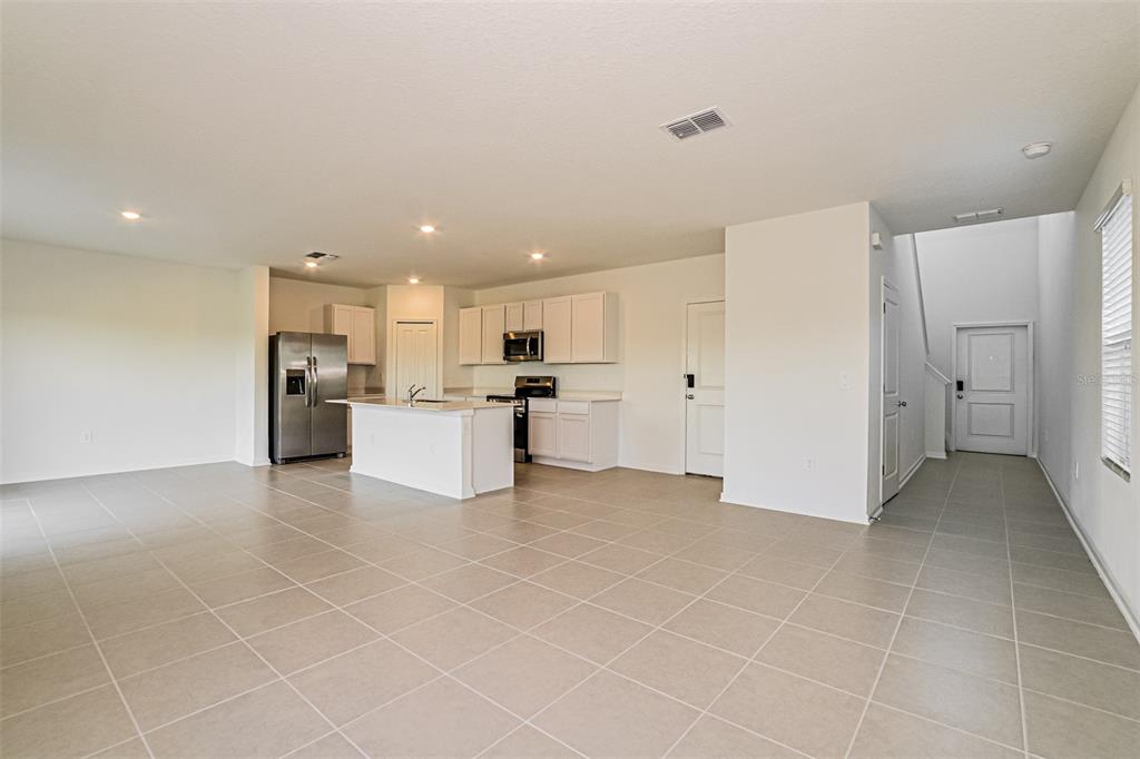 2207 Chris Drive Lake Wales, FL 33859 - Photo 5 of 16 a view of a kitchen with refrigerator and white cabinets