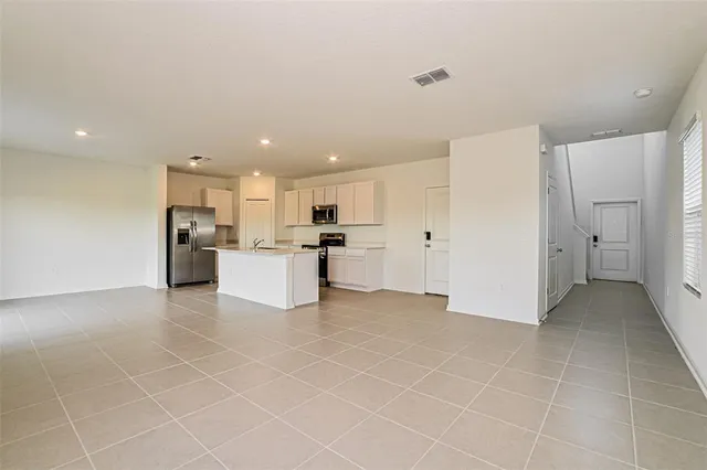 a view of a kitchen with refrigerator and white cabinets