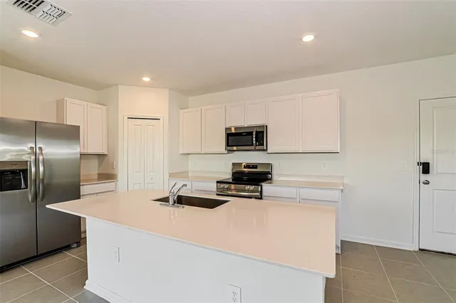 a kitchen with stainless steel appliances a refrigerator stove microwave and sink