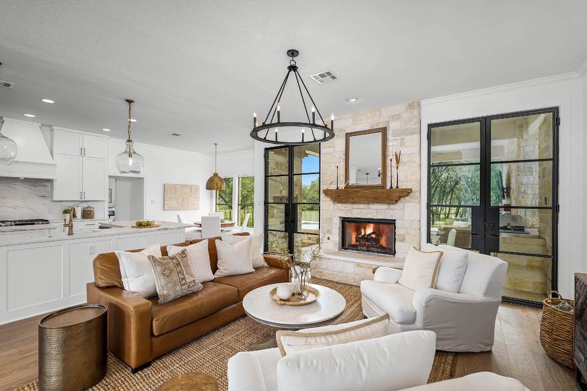 a living room with furniture a fireplace and a chandelier