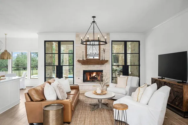 a living room with furniture a fireplace and a floor to ceiling window