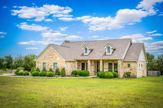 a view of a big house with a big yard and large trees