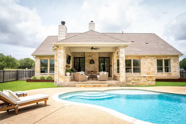a view of a house with swimming pool and porch with furniture