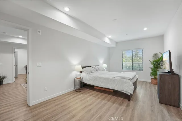 a bedroom with a bed and wooden floor