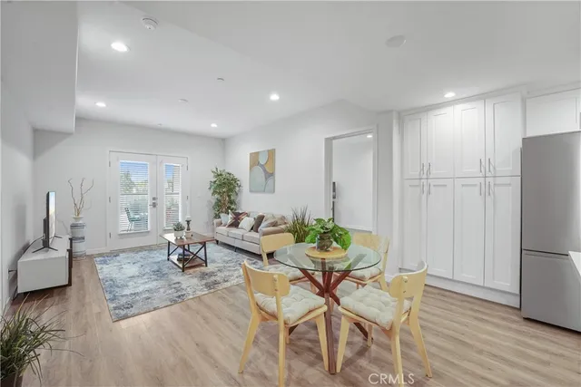 a living room with furniture wooden floor and a refrigerator