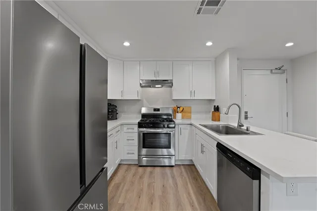 a kitchen with cabinets stainless steel appliances and a sink