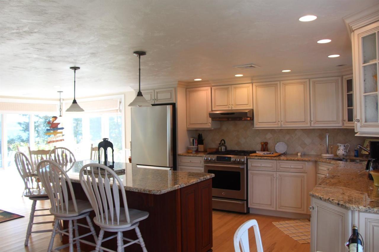 206 Clipper Road Bourne, MA 02532 - Photo 19 of 35 a kitchen with a table chairs refrigerator and microwave