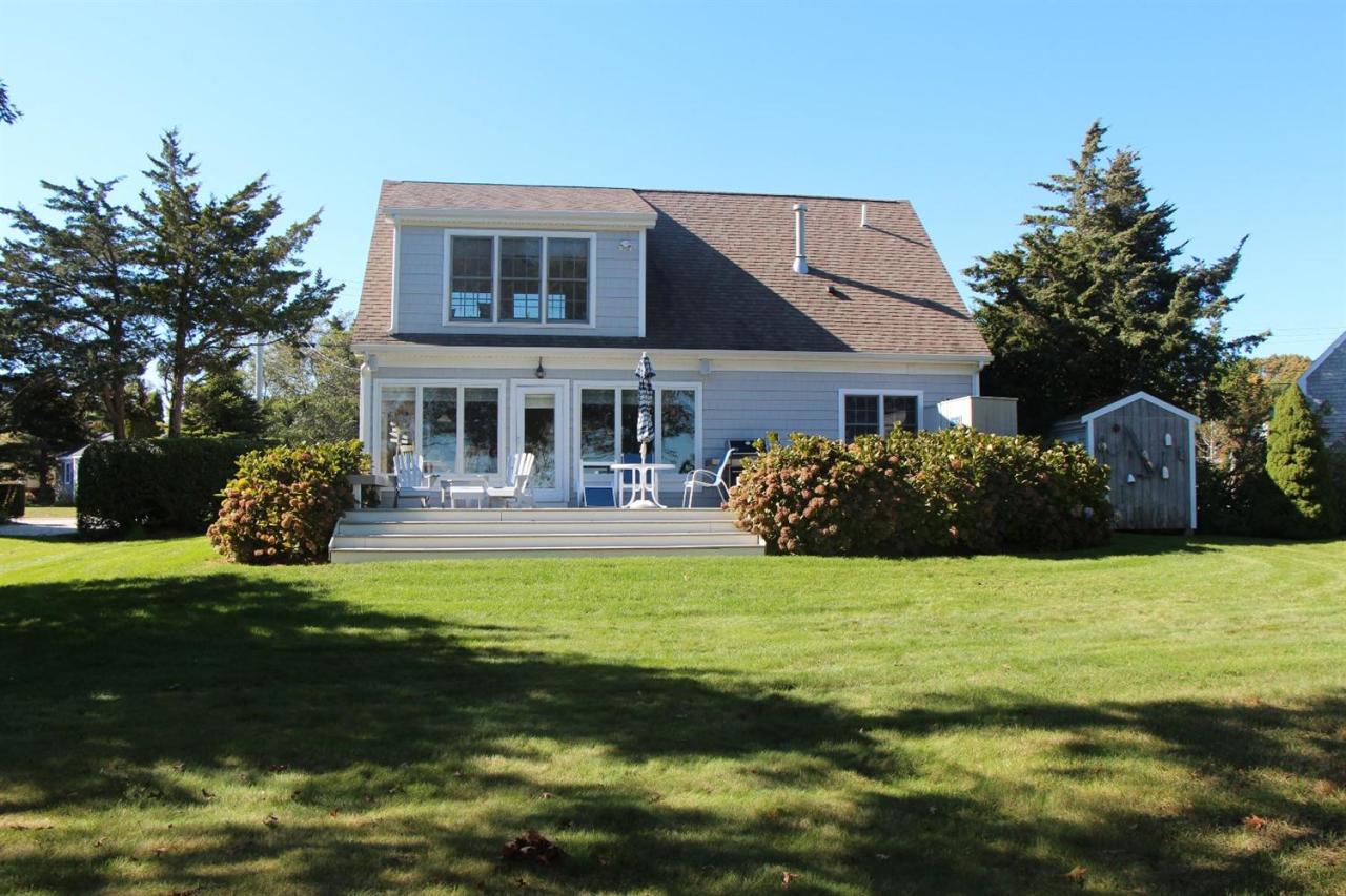 206 Clipper Road Bourne, MA 02532 - Photo 7 of 35 a front view of a house with a garden and lake view