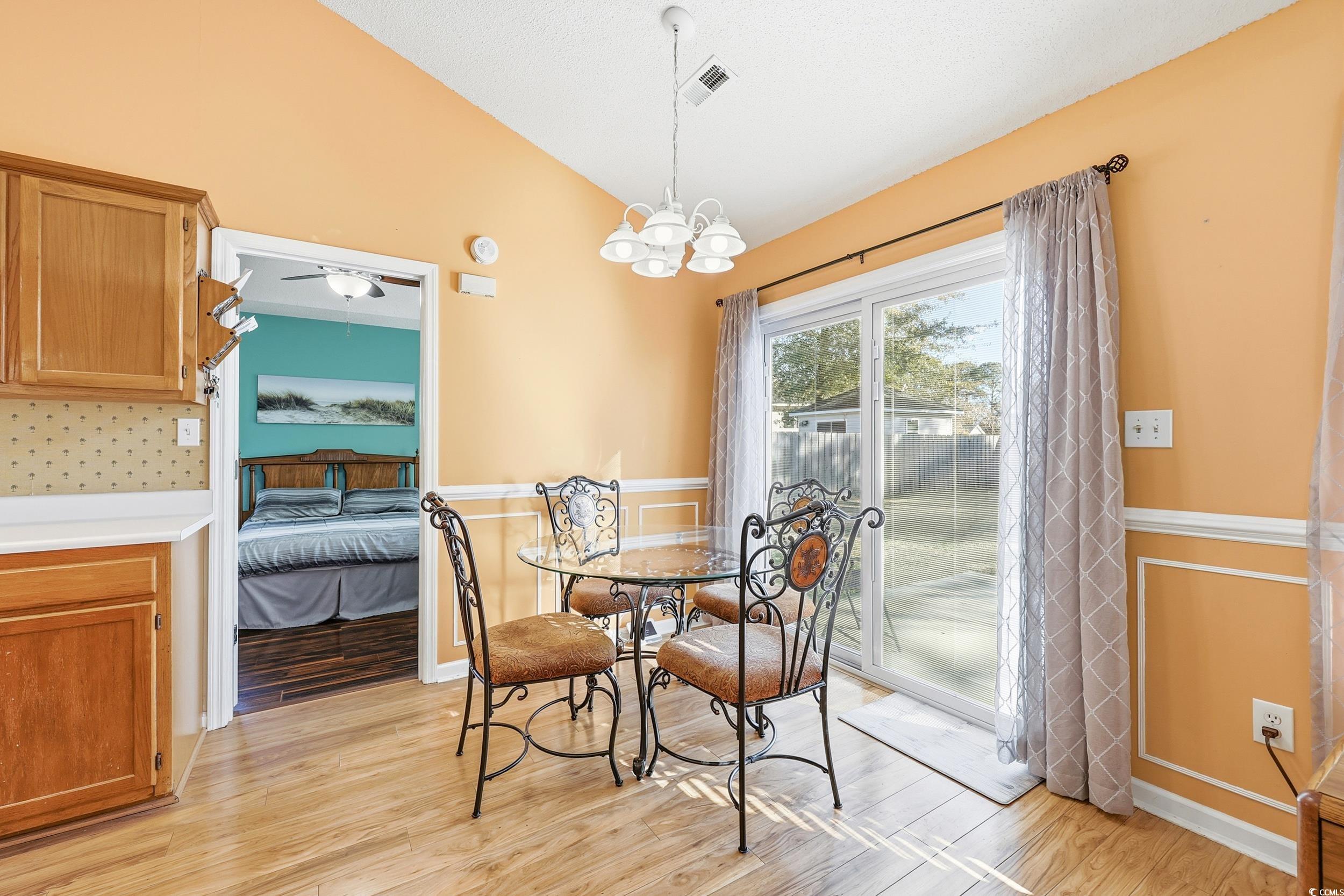 2560 Wild Game Trail Myrtle Beach, SC 29588 - Photo 7 of 24 Dining room featuring vaulted ceiling, light wood-style floors, and a chandelier