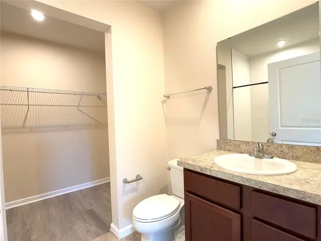 a bathroom with a granite countertop sink toilet and shower
