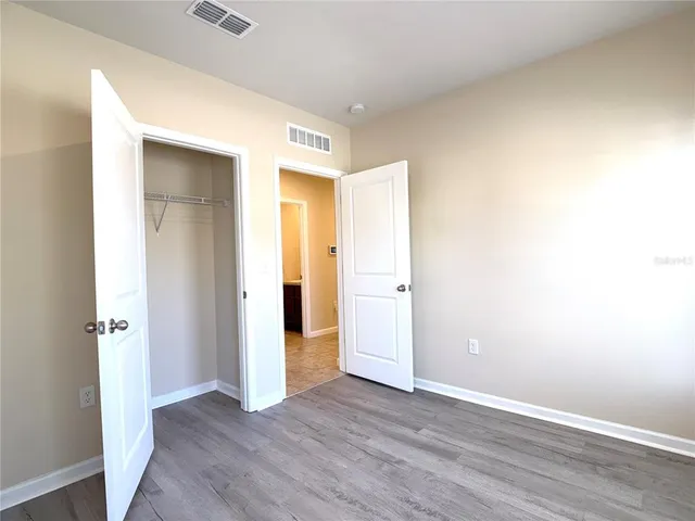 an empty room with wooden floor and closet