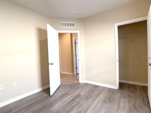 an empty room with wooden floor and closet